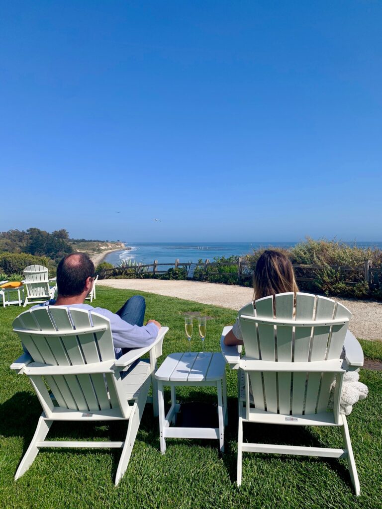 couple sitting in chairs overlooking the coast